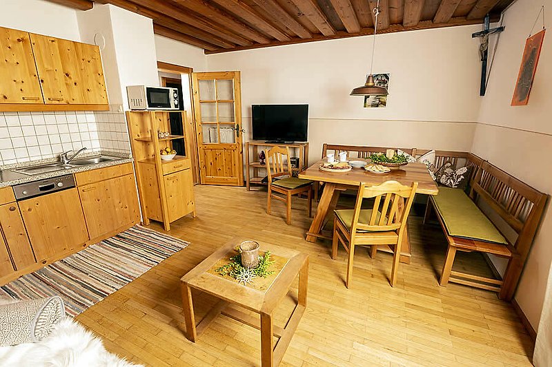 Gemütliche Einrichtung mit stilvollem Holzmobiliar und moderner Küche.