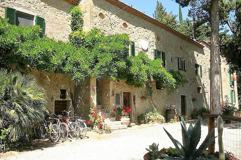 Casa di campagna con fiori, biciclette e finestre.