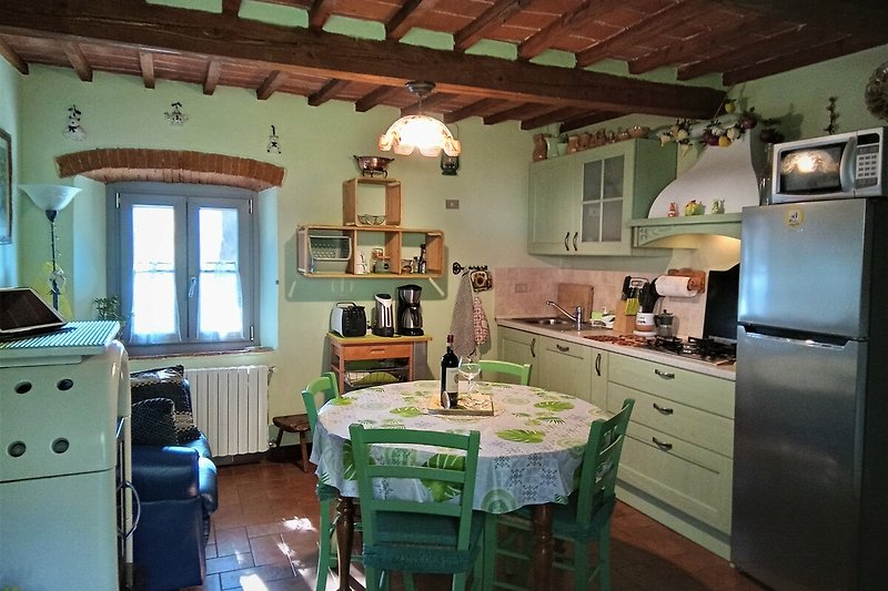 Una cucina rustica con mobili in legno, piano di lavoro e finestra.