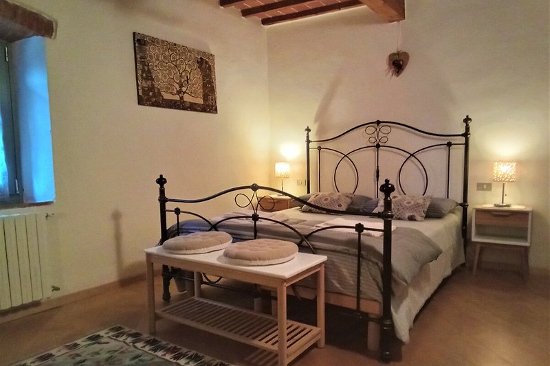 Una camera da letto con un letto a baldacchino in legno e una lampada a soffitto.