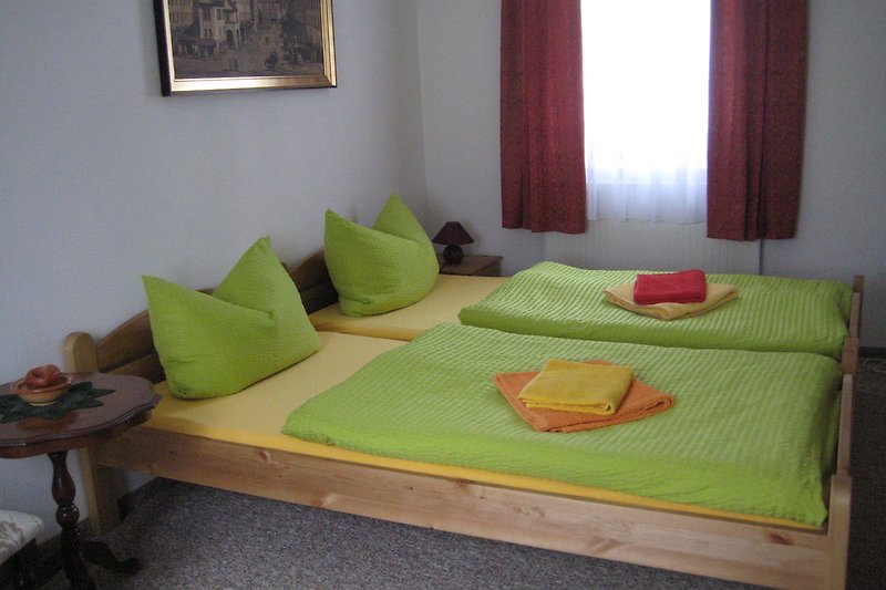 Elegantes Schlafzimmer mit Holzbett, gemütlichen Kissen und stilvoller Dekoration.