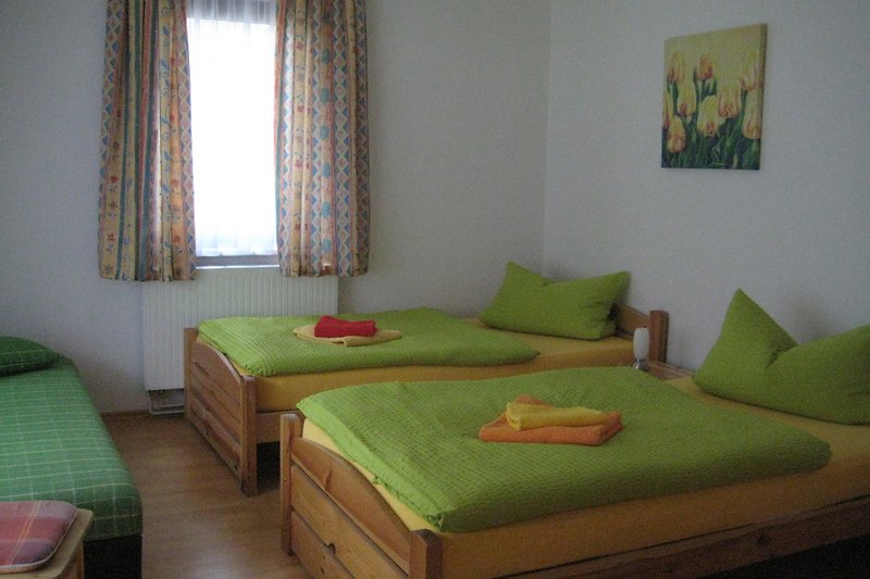 Stilvolles Schlafzimmer mit Holzbett, gemütlichen Kissen und kunstvoller Dekoration.
