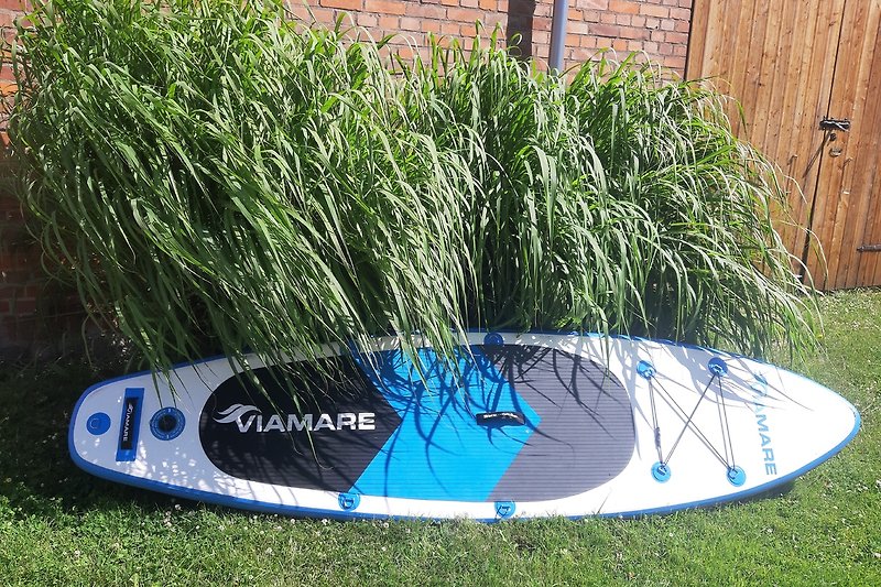 Wassersportparadies: Kajak und Surfbrett am Ufer.