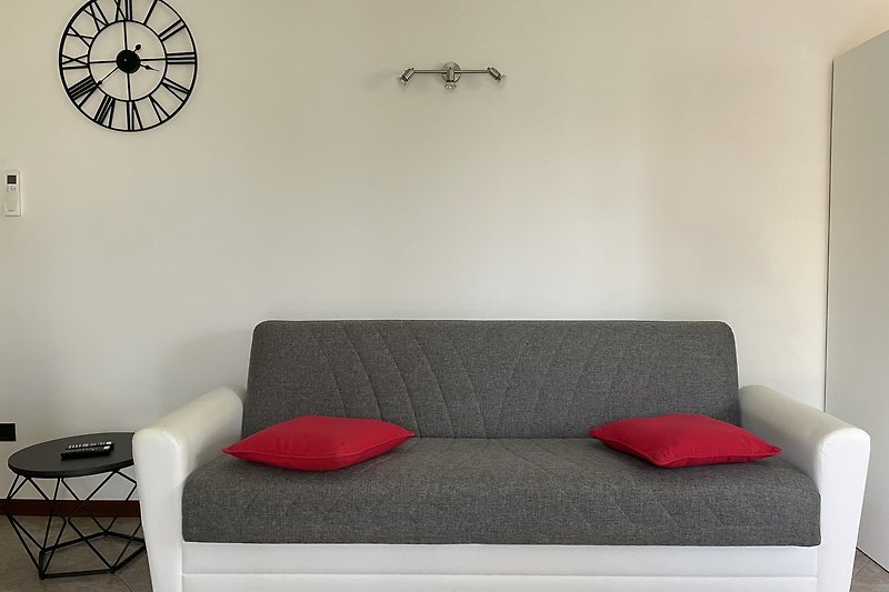 Modernes Wohnzimmer mit bequemer Couch, stilvollem Design und Uhr. Gemütliche Atmosphäre.