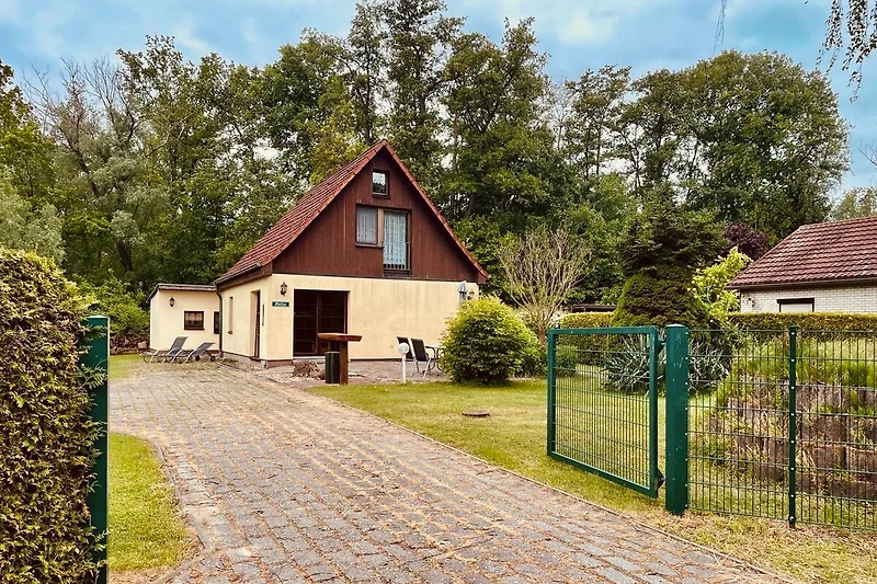 Ländliches Anwesen mit gepflegtem Garten und Einfahrt.