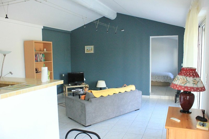 Wohnzimmer mit Holzboden, bequemer Couch und Fernseher.