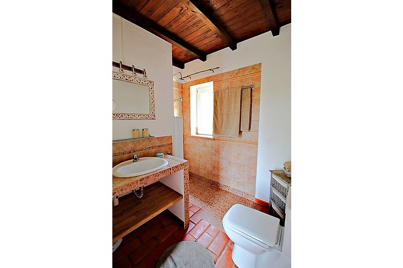 Ein modernes Badezimmer mit Holzboden und Fenster.