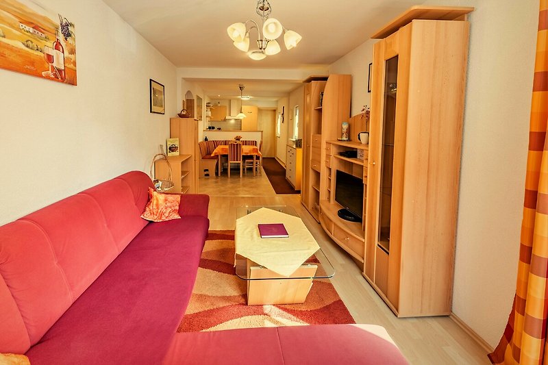 Gemütliches Wohnzimmer mit Holzboden, stilvoller Beleuchtung und bequemer Couch.