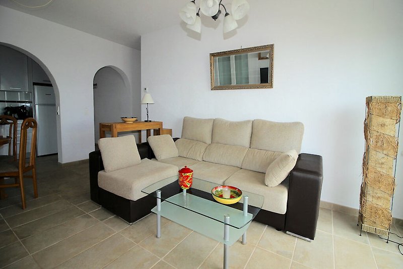Modernes Wohnzimmer mit grauem Sofa, Holzmöbeln und stilvoller Beleuchtung.