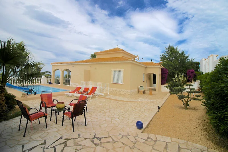 Ferienhaus mit Garten, Terrasse, Palmen und Stadtblick.