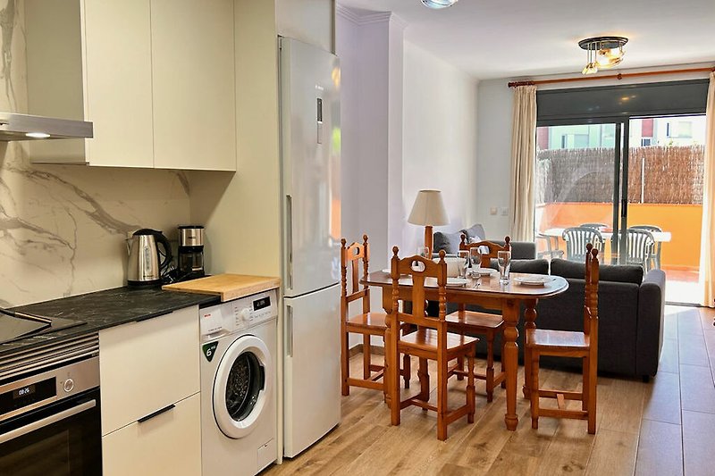 Moderne Küche mit Waschmaschine, Trockner, Schränken und Holzboden.
