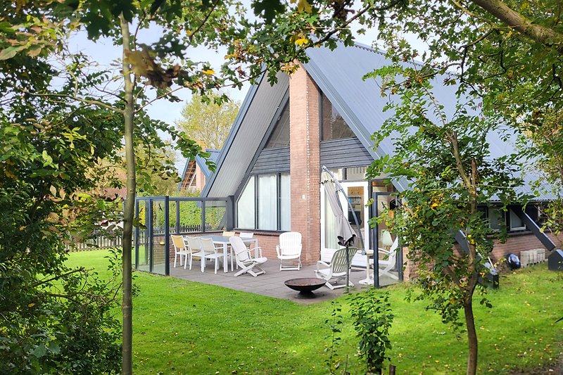 Charmantes Landhaus mit Garten, Bäumen und malerischer Fassade.