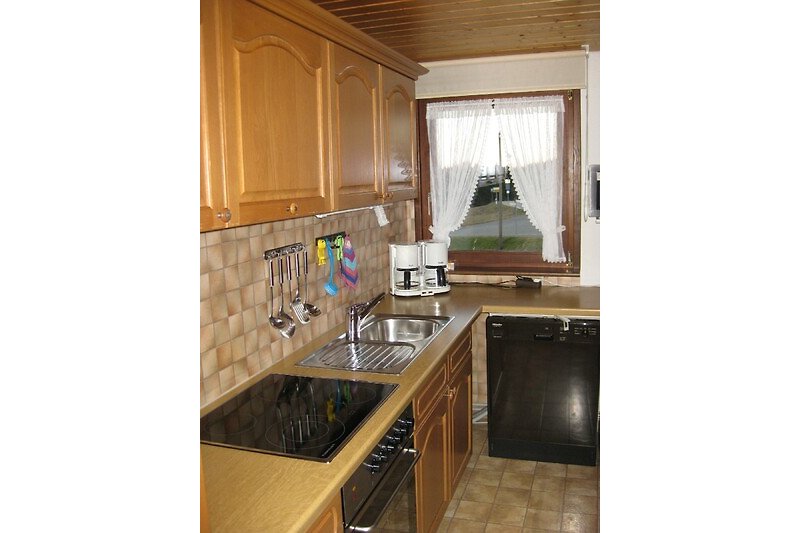 Gemütliche Küche mit Holzschränken und Granitarbeitsplatte.