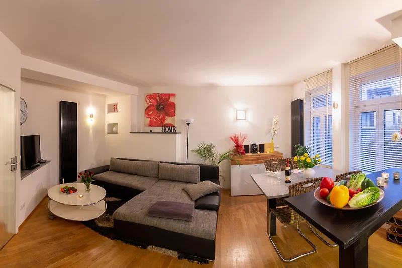 Großzügiger Wohnbereich mit Sofa, Esstisch, TV und stilvollem Licht.