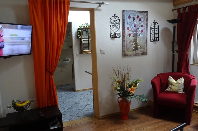 Stilvolles Wohnzimmer mit Holzmöbeln und Blumen.