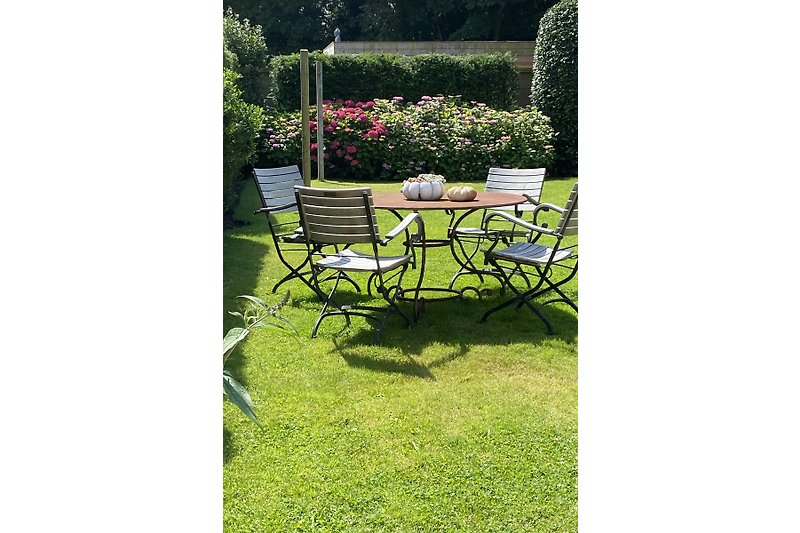 Gartentisch mit 6 Stühlen, 2 Sonnenliegen, einer Gartenbank für 6 Personen, 2 Sonnenschirmen und eine Hängematte.