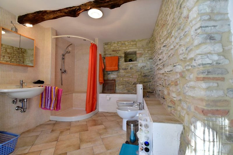 Großes Badezimmer mit Natursteinwänden