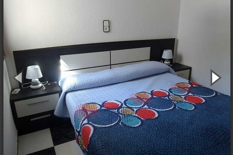 Modernes Schlafzimmer mit stilvollem Bett und gemütlicher Einrichtung.