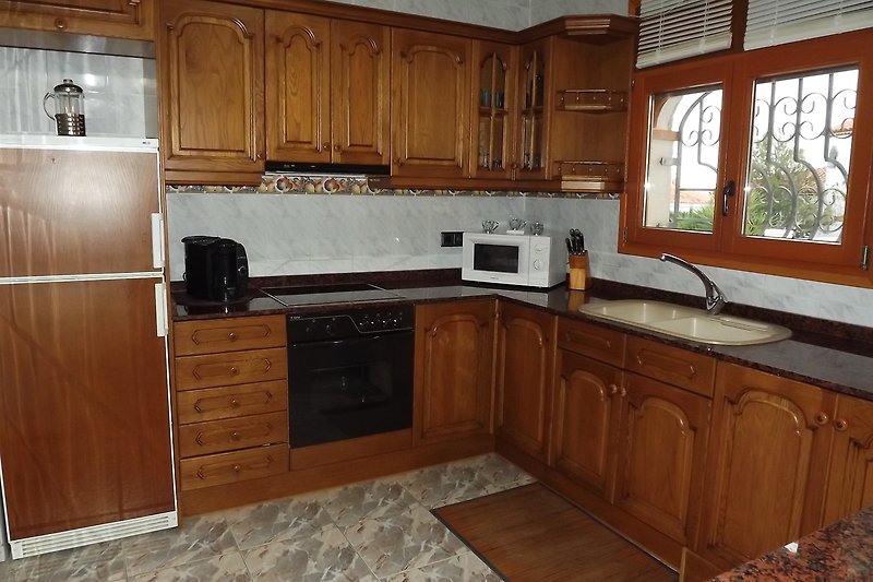 Moderne Küche mit Holzboden, Fenster und stilvoller Einrichtung.