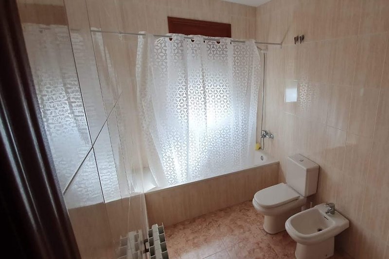 Moderne Badezimmerausstattung mit Holzboden und Fenster.