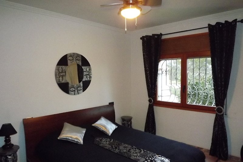 Komfortables Wohnzimmer mit Holzboden, Fenster und Pflanzen.