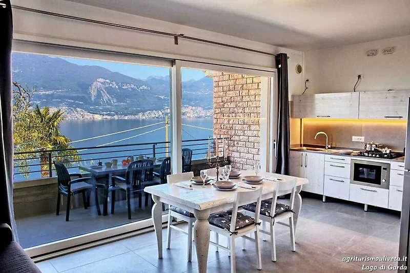 Gemütliche Terrasse mit Seeblick, stilvollen Möbeln und Pflanzen.
