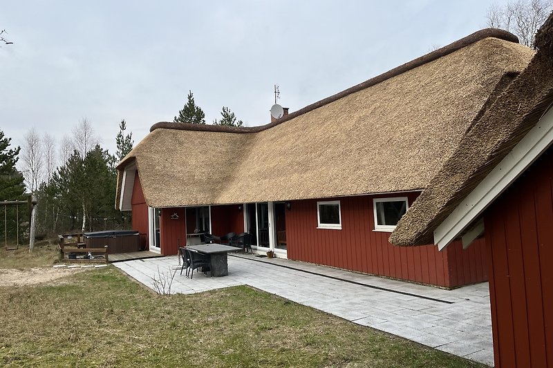 Traditionelles Landhaus mit Reetdach und Holzfenstern.