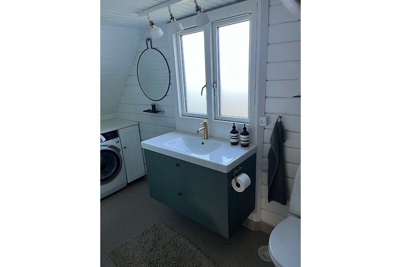 Moderne Badezimmerausstattung mit Spiegel, Waschbecken und Armatur.