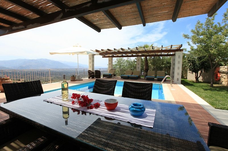Schöne Terrasse mit Pool, Garten und Outdoor-Möbeln.