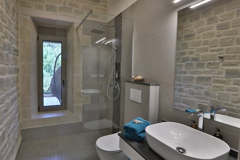Badezimmer zu SZ 2 ;mit Spiegel, Waschbecken, Dusche und Fenster.