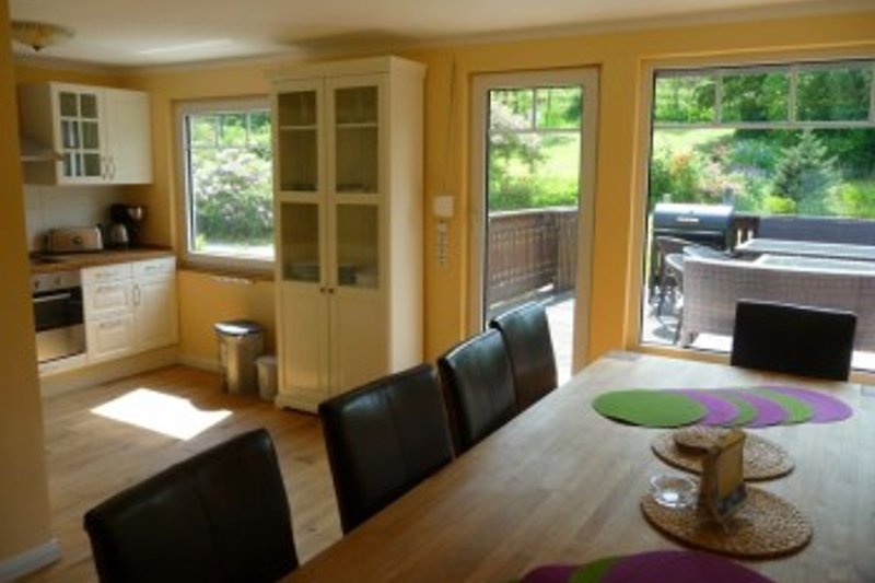 View over the dining table to the open kitchen and terrace.