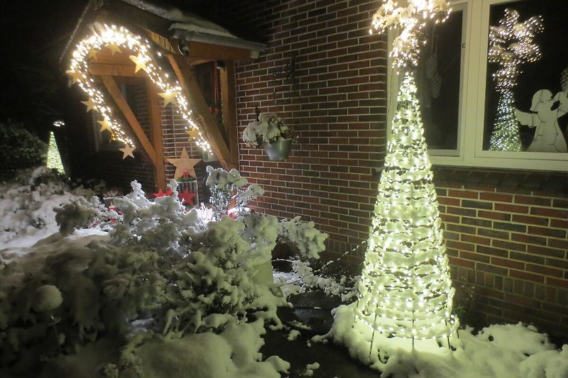 Genießen Sie die festliche Atmosphäre mit Weihnachtsbaum, Lichtern und Schnee.