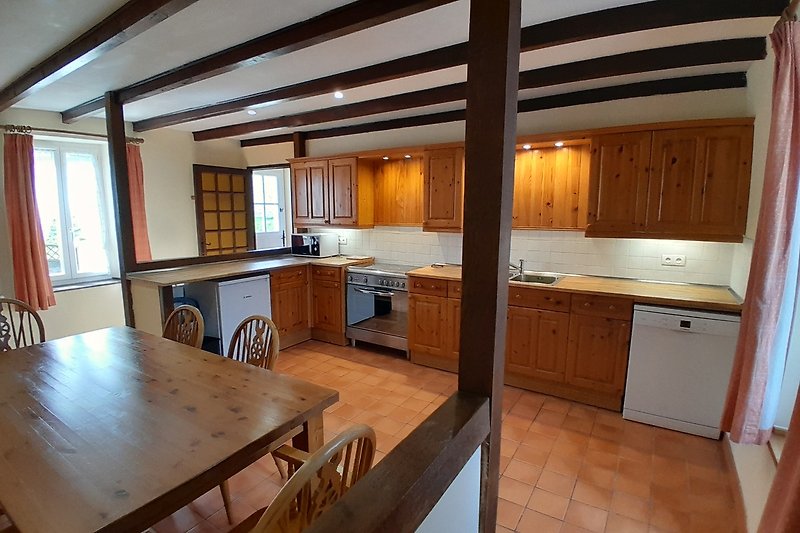 Küche mit Holzmöbeln, Fenster und Spüle.
