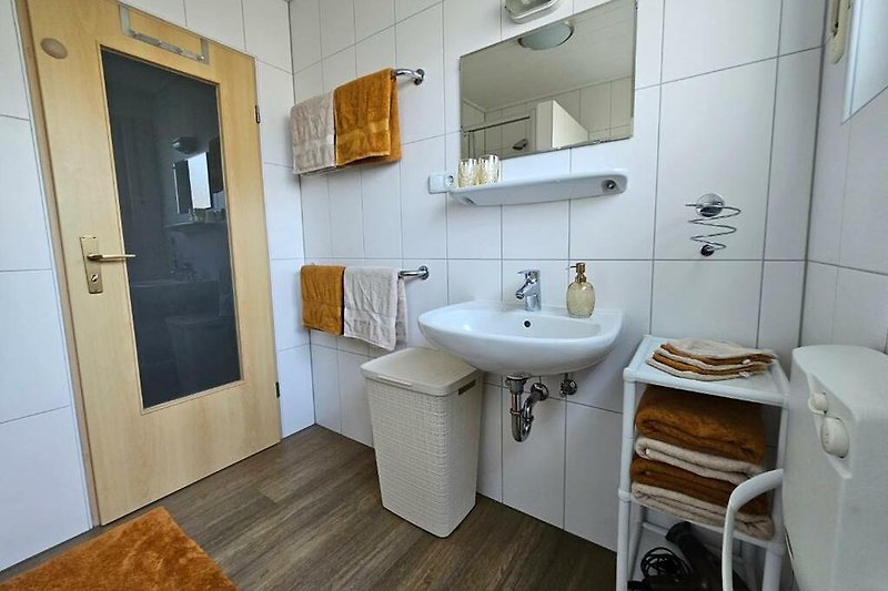 Modernes Badezimmer mit lila Akzenten, Holzboden und Keramikfliesen.