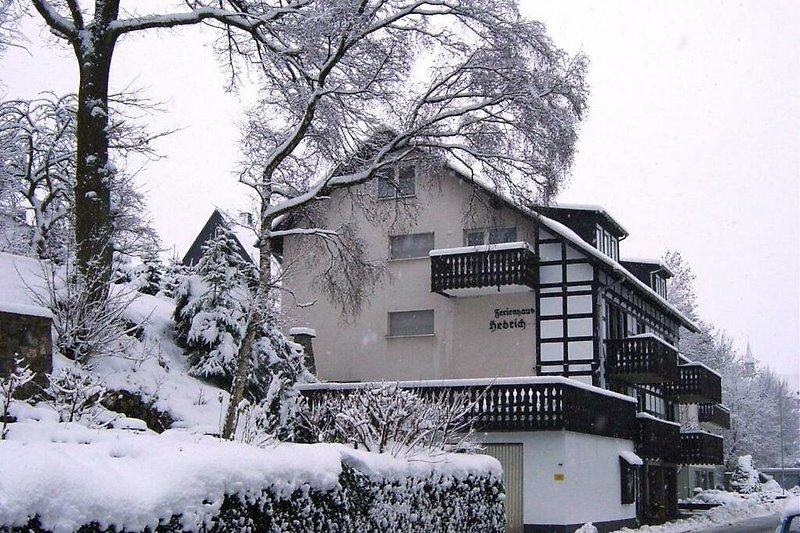 Ein winterliches Haus mit Schnee bedeckt und einem gemütlichen Kamin.