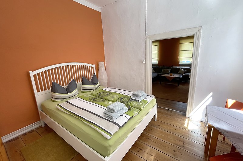 Schlafzimmer mit Holzdielenboden und gemütlichem Bett