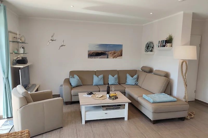 Sofa mit Kissen, Sessel, Couchtisch und dekorativem Bilderrahmen.