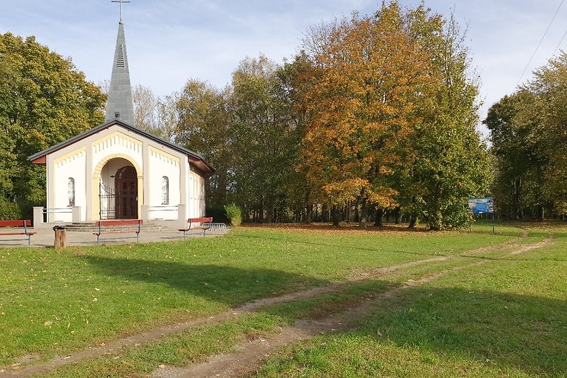 Schöne ländliche Landschaft mit Kirche und grüner Wiese.