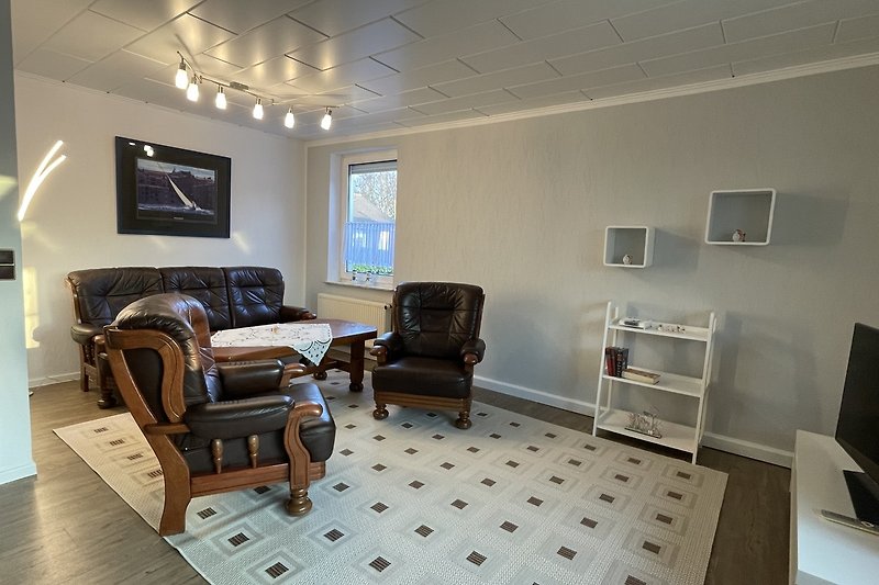 Stilvolles Wohnzimmer mit bequemen Möbeln und HD-Fernseher