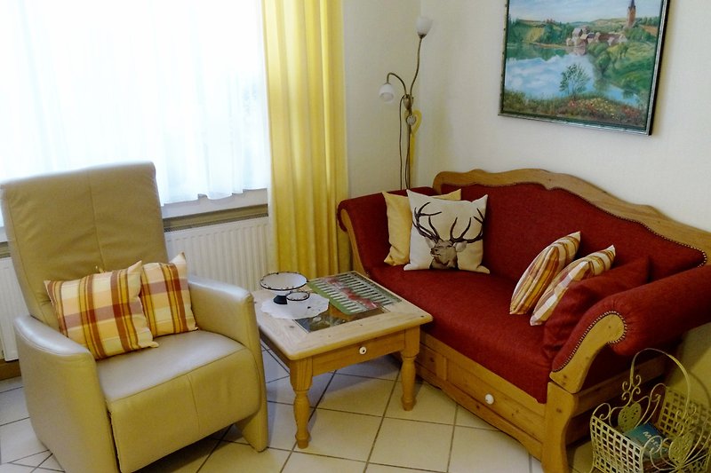 Gemütliches Wohnzimmer mit bequemer Couch, Holzmöbeln und stilvoller Dekoration.