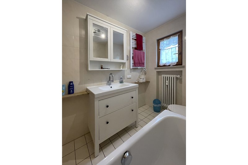 Badezimmer mit weißem Waschbecken und Spiegel.
