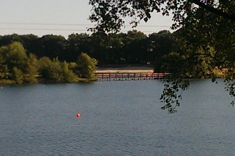 Blick auf die Holzbrücke über den See