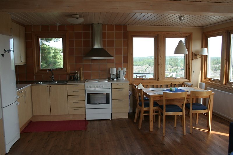 Küche mit Holzoberflächen, Pflanzen und Fenster.