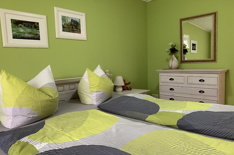 Gemütliche Einrichtung mit Holzmöbeln, grünen Pflanzen und gemütlichem Bett.