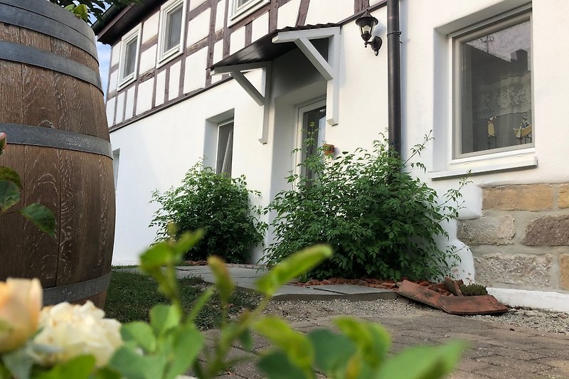 Fassadenblumen und grüner Garten vor dem Haus.