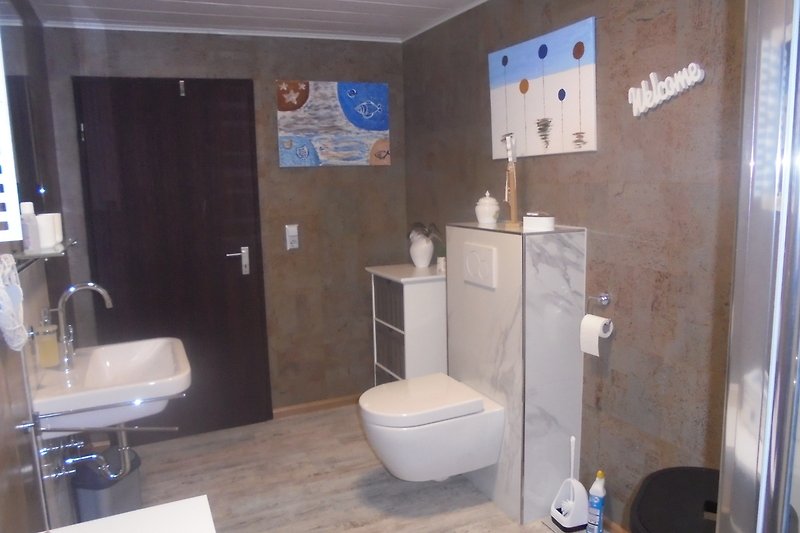 Badezimmer mit lila Akzenten, Keramikwaschbecken und Dusche.