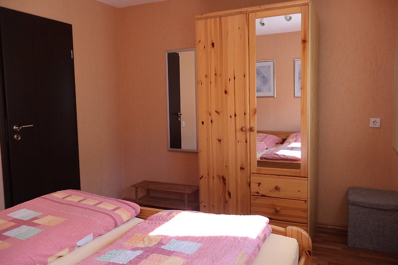 Schlafzimmer mit gemütlichem Bett und Holzmöbeln.
