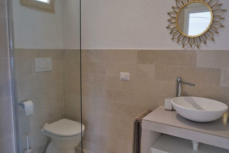 Schönes Badezimmer mit lila Wand, Holzboden und stilvollem Waschbecken.