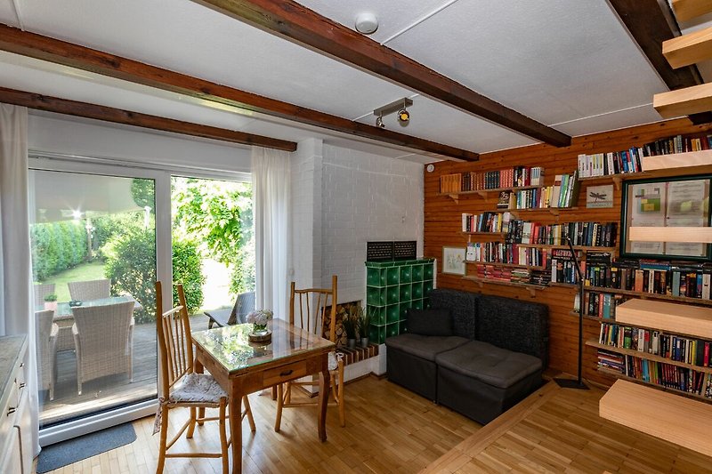 Wohn- Esszimmer mit  Fernseher,  gemütliches Sofa und Bücherecke am Ofen . Insektenschutz & Klimaanlagen in allen Räumen