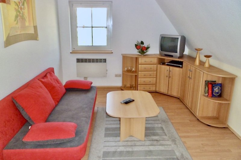 Moderne Wohnzimmerausstattung mit Fernseher und bequemer Couch. Wohnung 2